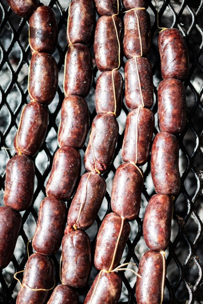 Close-up of traditional Argentine chorizo sausages being prepared on a grill in Uribelarrea, Buenos Aires.